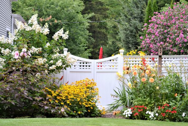Durable white vinyl picket fence with gate in a front yard in Bartlett, Tennessee